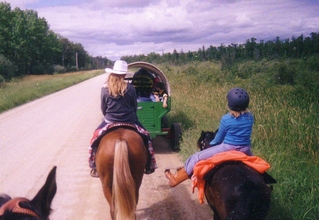 Two young riders, one with a cowboy hat and one with a helmet