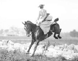 Woman jumping wall with sidesaddle