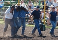 Rodeo contestant being helped away from a good ride